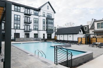 A large white building with a pool in front.